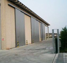 Portone scorrevole a due ante sovrapposte con porta inserita